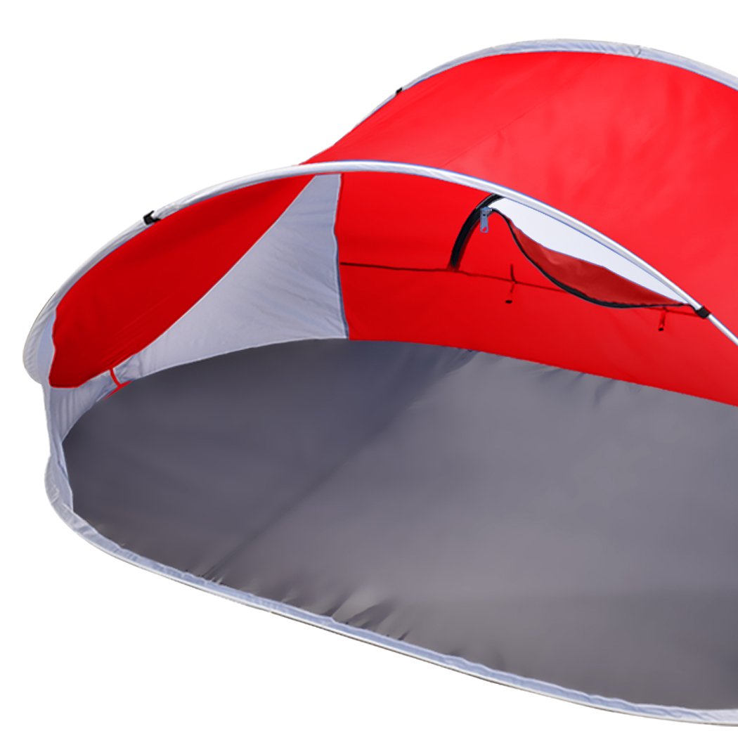Mountvie Pop Up Tent in red color, spacious enough for 4 people, set up on a beach with a carry bag beside it.